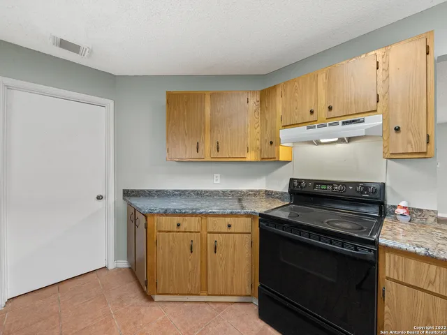 a kitchen with granite countertop a stove and a sink