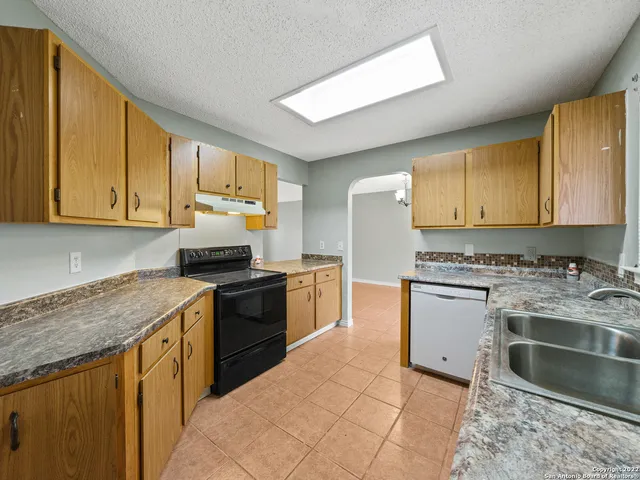 a kitchen with a sink stove top oven and cabinets