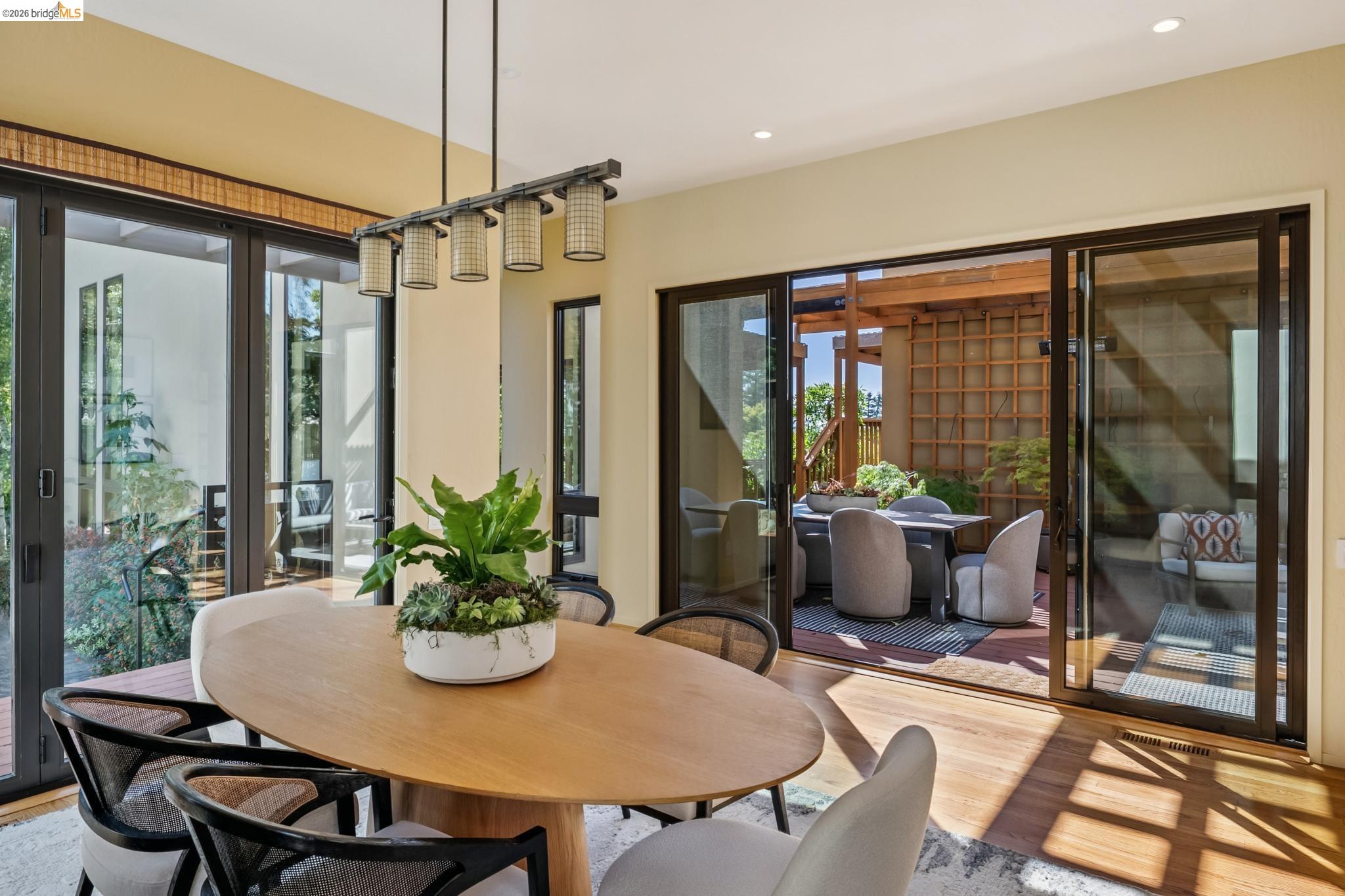 576 Vistamont Avenue Berkeley, CA 94708 - Photo 14 of 33 Open-concept dining space featuring a modern linear chandelier, light wood-finish flooring, and recessed lighting
