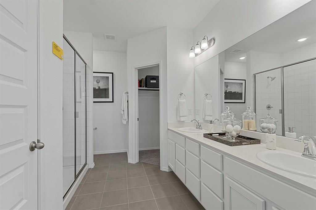 a spacious bathroom with a double vanity sink a mirror and shower