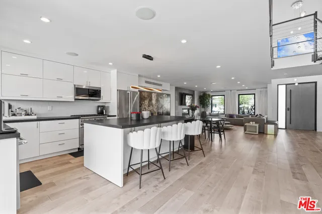 a kitchen with lots of counter top space and painting on the wall