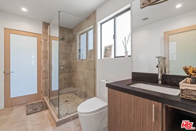 a bathroom with a granite countertop sink toilet and shower