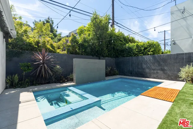 a view of a backyard with table and chairs under an umbrella