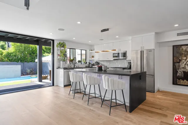 a kitchen with stainless steel appliances granite countertop a refrigerator and a stove top oven