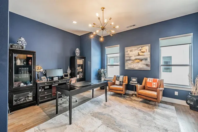 a living room with furniture a chandelier and a flat screen tv