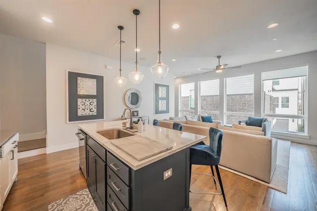 a kitchen with a sink a counter top space and living room view