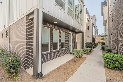 a view of a brick house with a large windows and plants