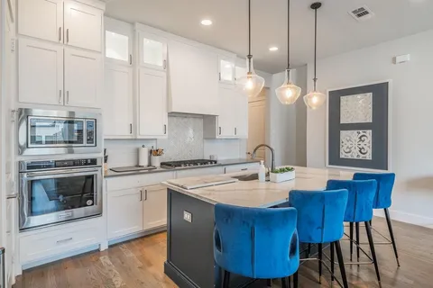 a kitchen with a stove a sink a dining table and chairs