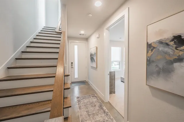 a view of a hallway with stairs and wooden floor