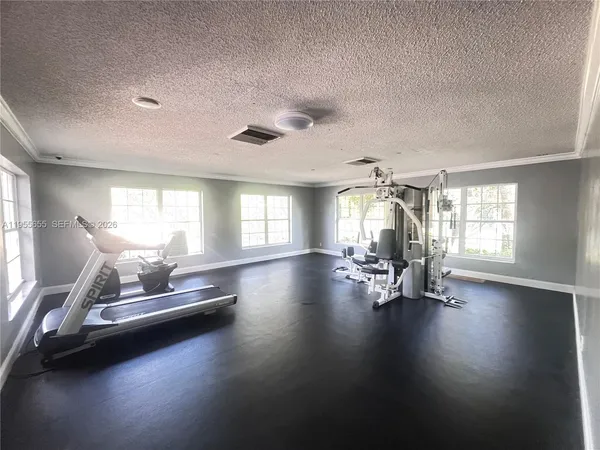 a view of a room with gym equipment and windows