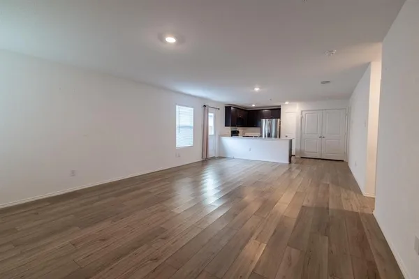 a view of a big room with wooden floor and windows