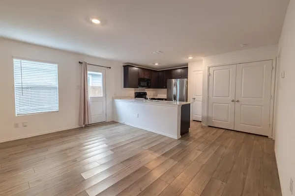 a view of a kitchen with wooden floor and electronic appliances
