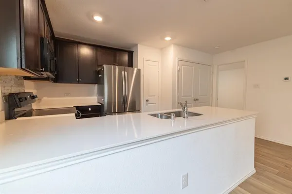 a view of a kitchen with a sink and refrigerator