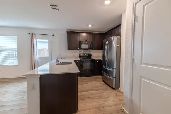 a kitchen with refrigerator cabinets and wooden floor