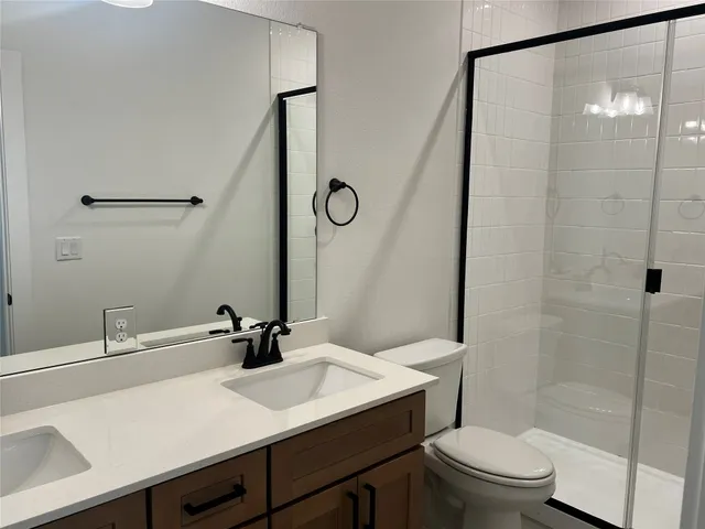 a bathroom with a sink toilet a mirror and shower