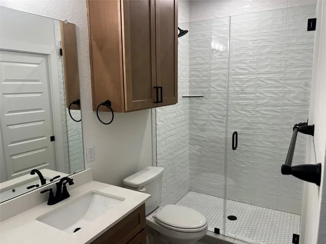 a bathroom with a sink a toilet and shower