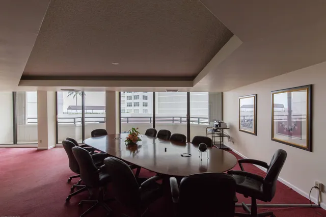a living room with furniture a table and large windows