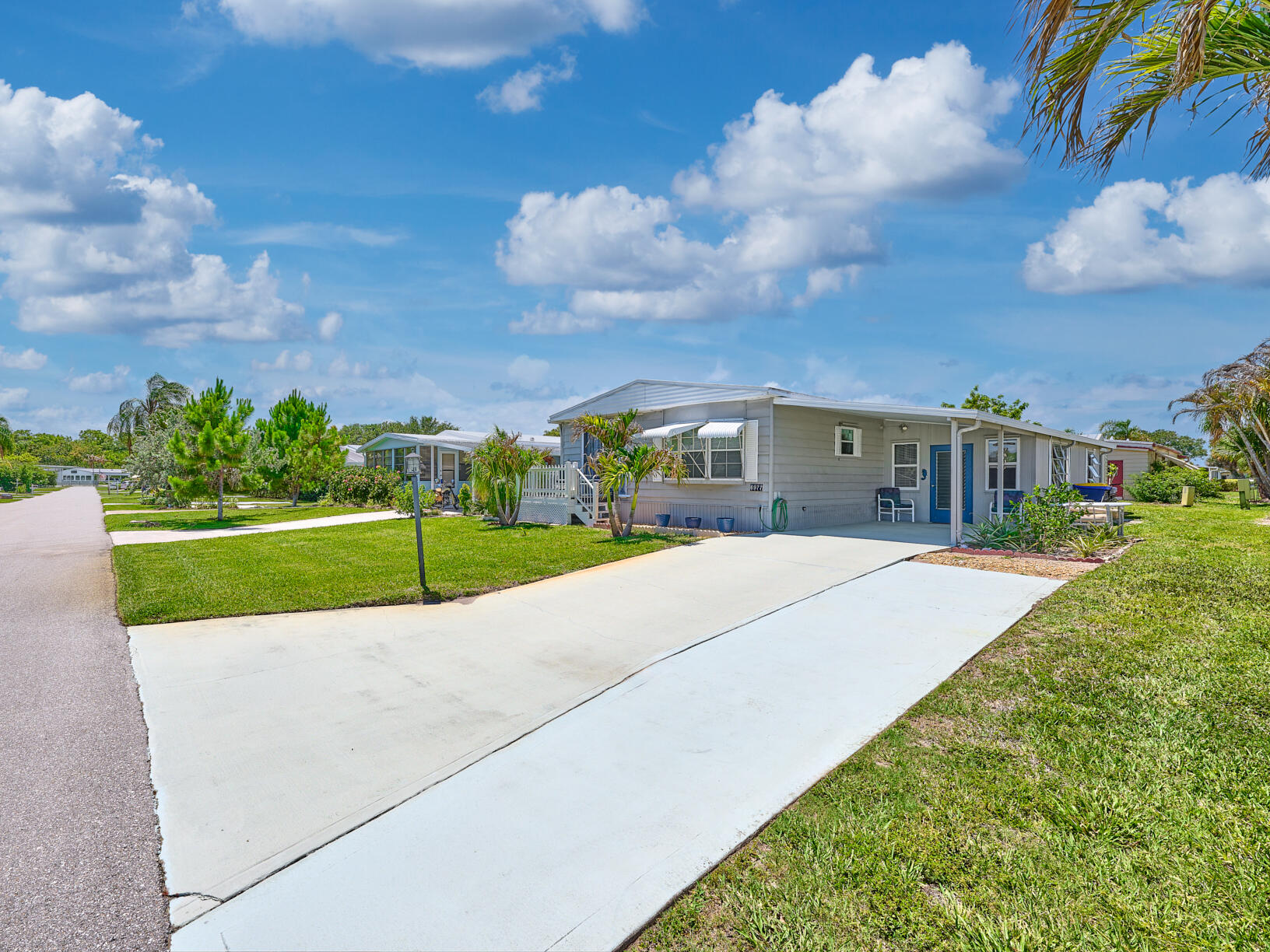 6977 Southeast Delegate Street Hobe Sound, FL 33455 - Photo 4 of 60 a house with green field in front of it