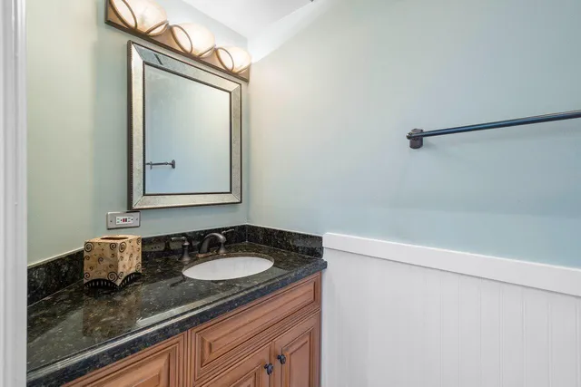 a bathroom with a granite countertop sink and a mirror