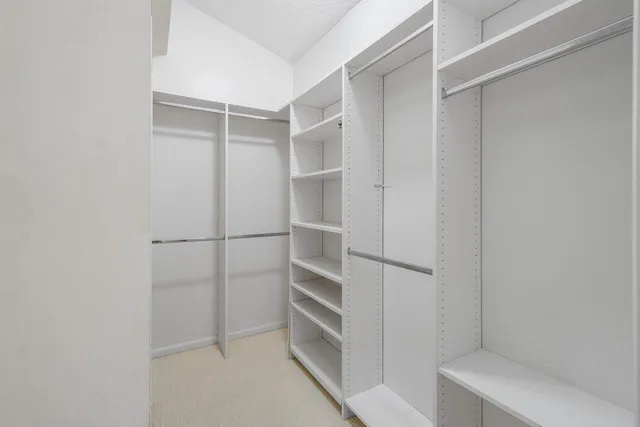 a view of walk in closet with empty racks