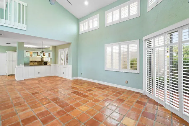 a view of an empty room with a window and a kitchen
