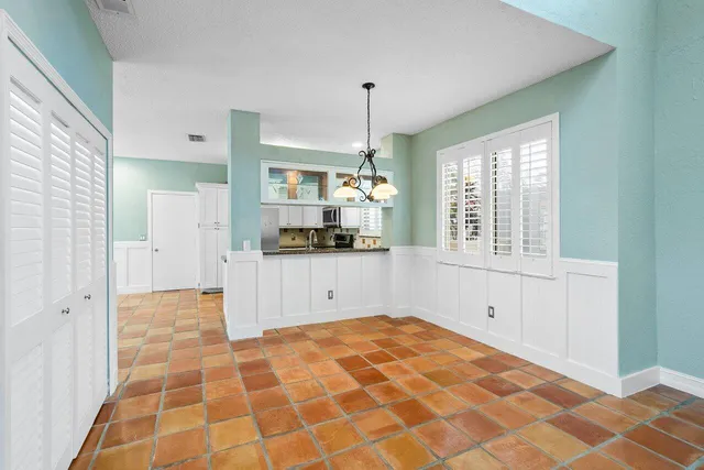 a kitchen with white cabinets and window