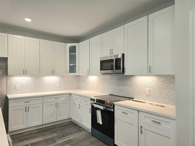 a kitchen with white cabinets stainless steel appliances and sink
