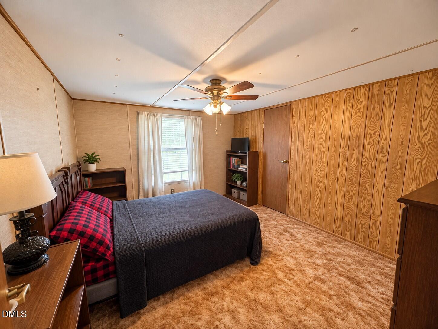 471 Kramer Road Lillington, NC 27546 - Photo 1 of 26 Wood-paneled wall, textured carpet, and a ceiling fan with light fixture