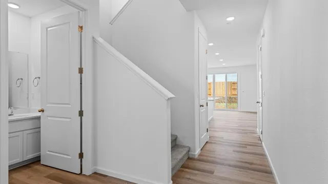 a view of a hallway with wooden floor and closet