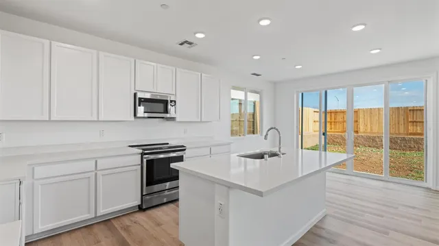 a kitchen with a sink stove and cabinets