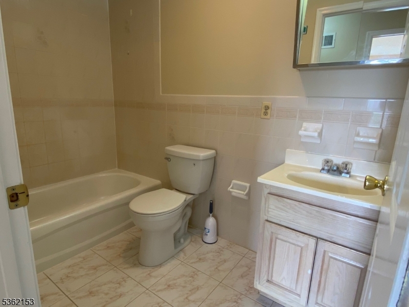 76 Union Street Newark, NJ 07105 - Photo 23 of 34 a bathroom with a toilet sink and mirror
