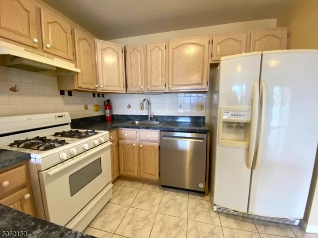 a kitchen with white cabinets and white appliances