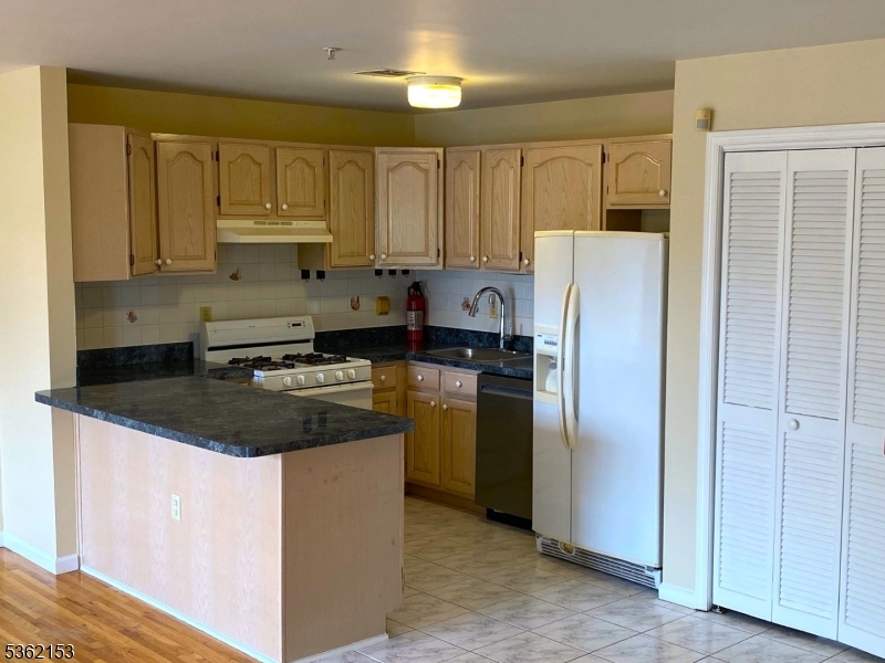 76 Union Street Newark, NJ 07105 - Photo 7 of 34 a kitchen with stainless steel appliances granite countertop a refrigerator a stove a sink and a microwave