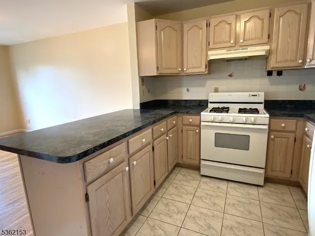 a kitchen with granite countertop white cabinets and white appliances