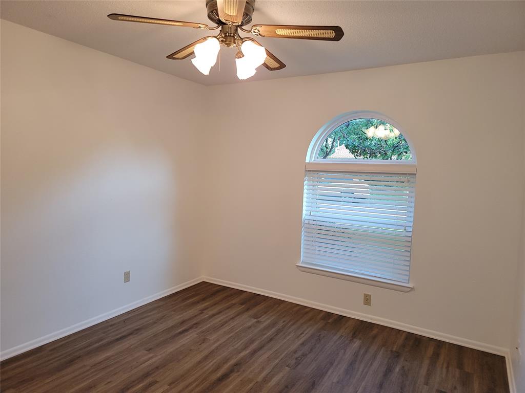 1000 Springdale Road Bedford, TX 76021 - Photo 20 of 36 Bedroom 2 has a ceiling fan and arched window.