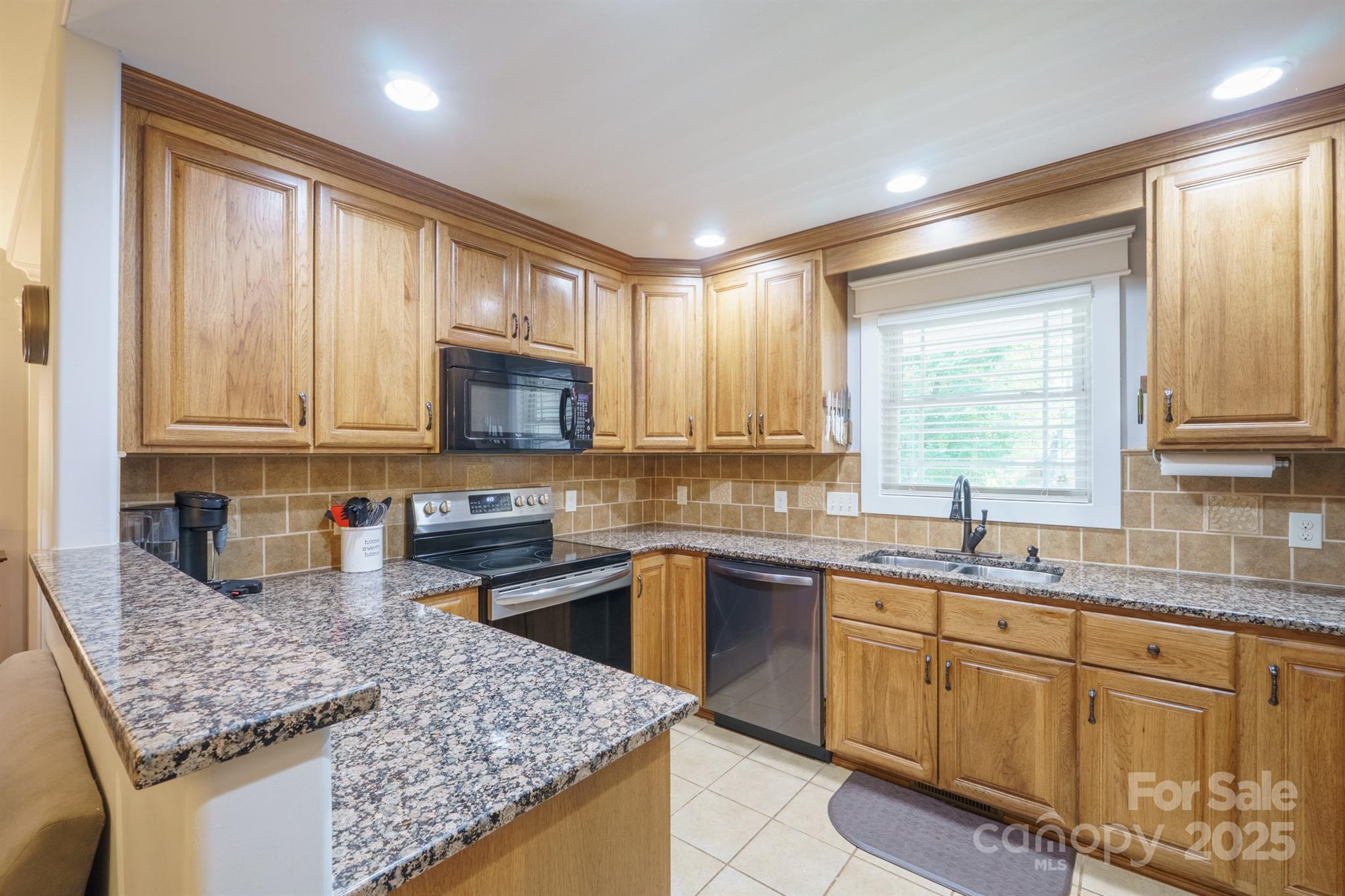 121 Jefferson Drive Locust, NC 28097 - Photo 5 of 22 a kitchen with granite countertop stainless steel appliances sink stove microwave and cabinets