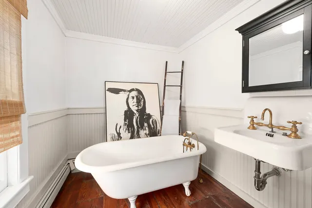 a bathroom with a bathtub a sink and a window