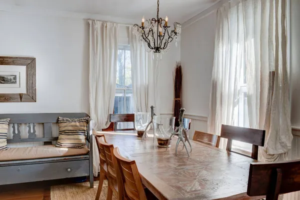 a dining room with furniture a chandelier and window