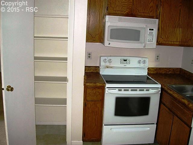 714 Prairie Road, Unit A & #B Colorado Springs, CO 80909 - Photo 16 of 22 Unit B panty along side smooth top stove and microwave in kitchen.
