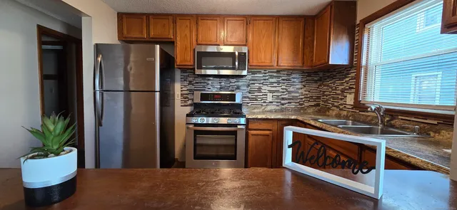 a kitchen with a refrigerator and a stove top oven