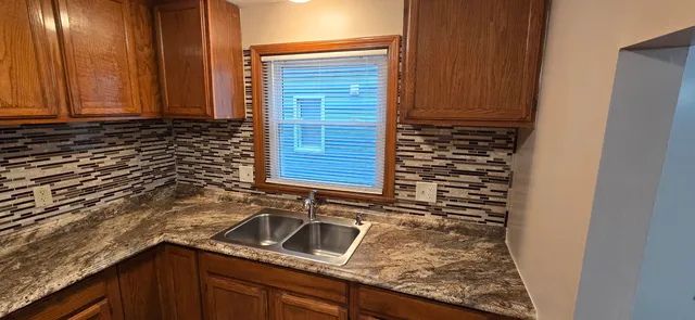a kitchen with granite countertop a sink and a stove