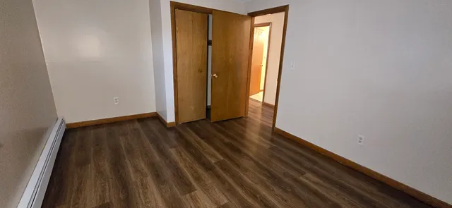 a view of a room with wooden floor and door