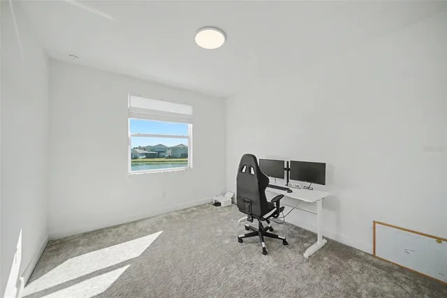 a sign that is sitting in the grass with large trees