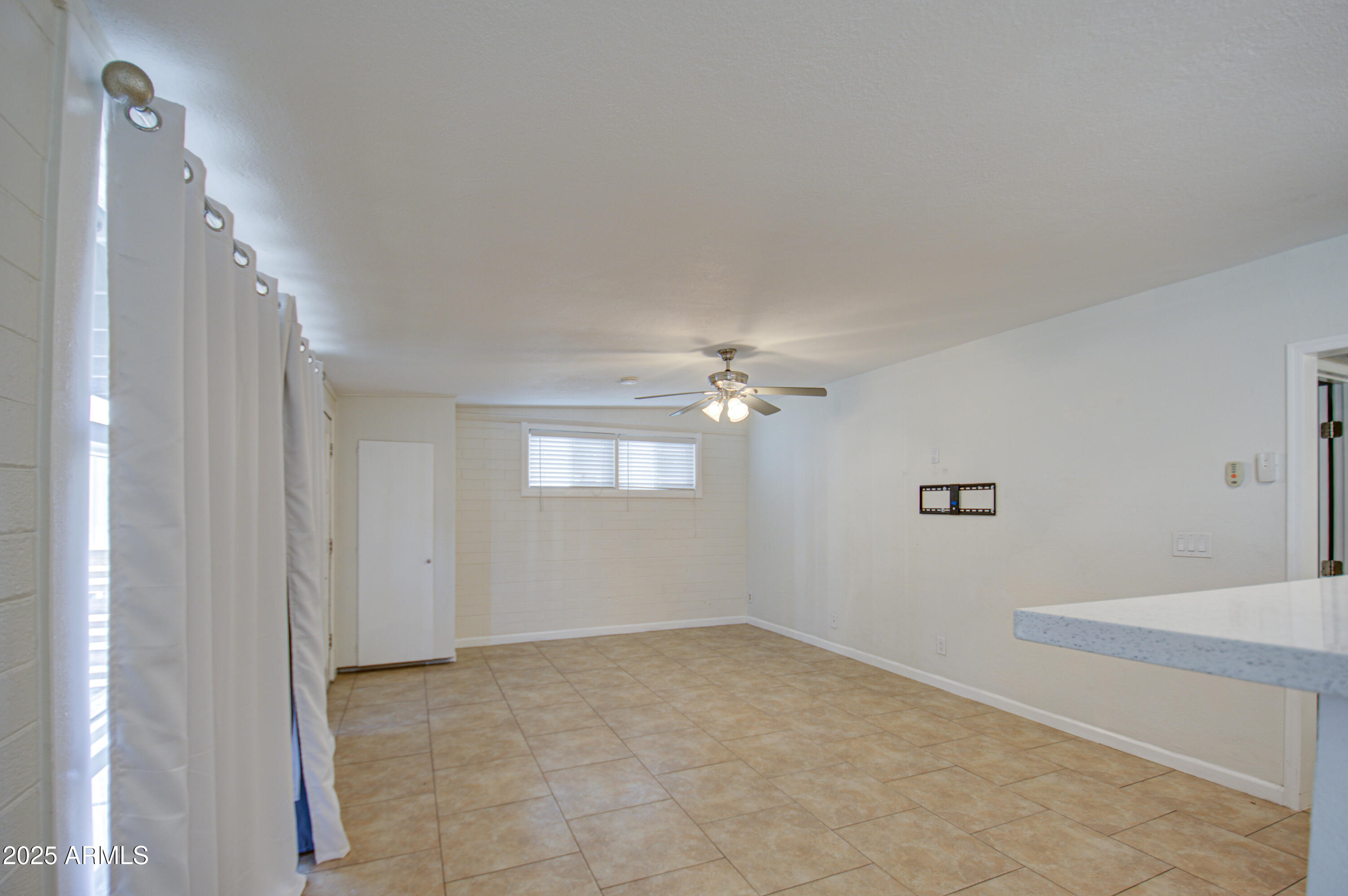 2937 East Osborn Road Phoenix, AZ 85016 - Photo 9 of 59 a view of an empty room with a chandelier fan
