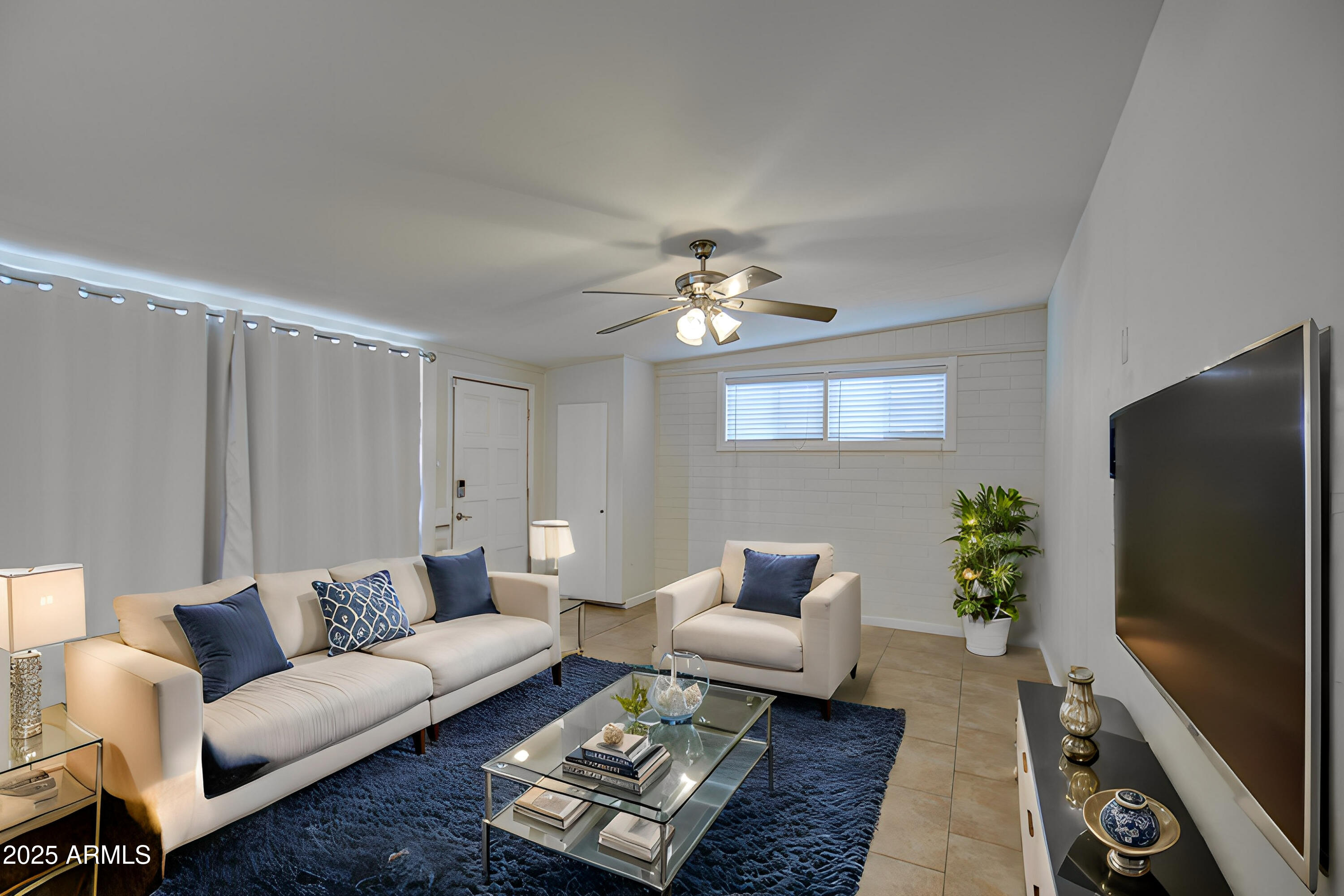 2937 East Osborn Road Phoenix, AZ 85016 - Photo 10 of 59 a living room with furniture a chandelier and a flat screen tv
