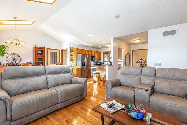 a living room with furniture a flat screen tv and a floor to ceiling window