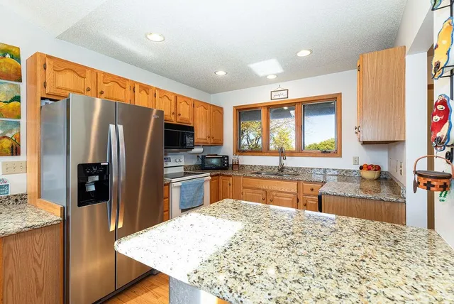 a living room with furniture a flat screen tv and kitchen view
