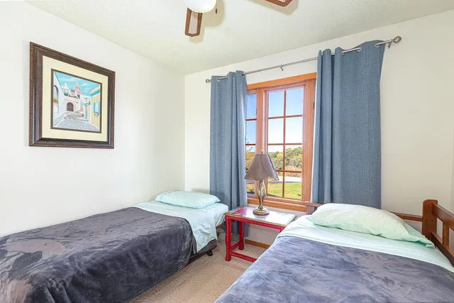 a living room with furniture kitchen view and a large window