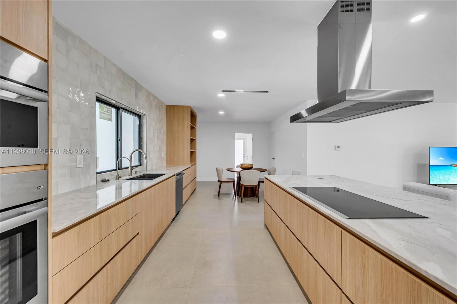 13407 Southwest 59th Avenue Pinecrest, FL 33156 - Photo 19 of 50 a large kitchen with stainless steel appliances granite countertop a lot of counter space and wooden floors
