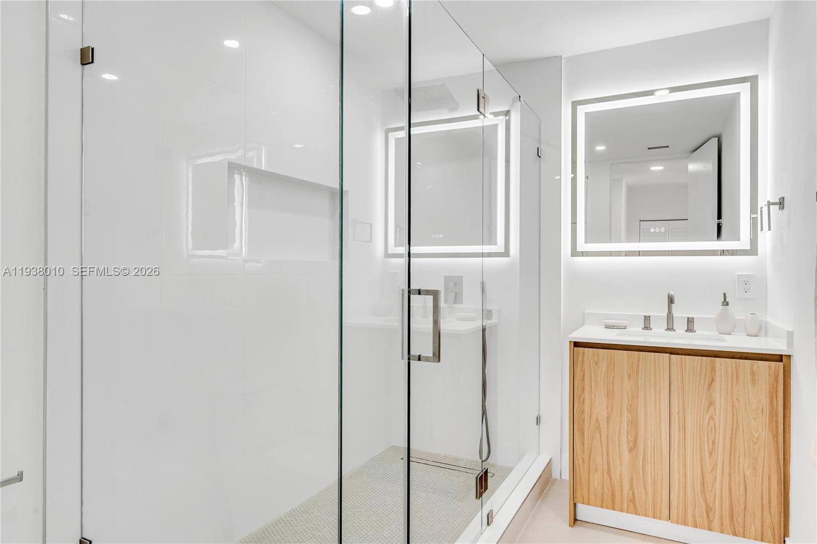 13407 Southwest 59th Avenue Pinecrest, FL 33156 - Photo 37 of 50 a bathroom with a shower a sink and a mirror